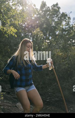 Nahaufnahme eines wunderschönen blonden Wanderer-Mädchens, das in den Wald geht Stockfoto