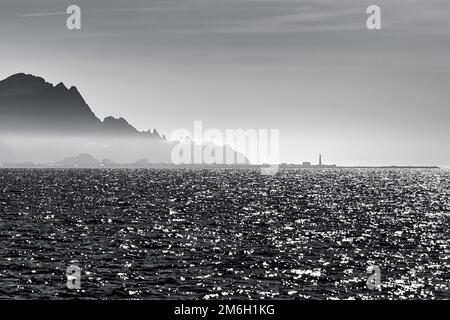 Glitzerndes Meer, felsige Küste bei Andenes, Silhouetten am Horizont, Schwarzweißfoto, Andoya, Vesteralen, Norwegen Stockfoto