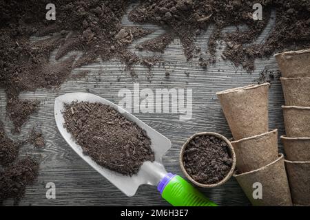 Landwirtschaftliche Torftöpfe Bodenspaten auf Holzbrettern. Stockfoto