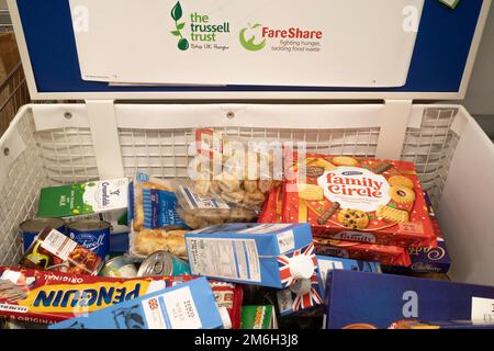 Spenderbox in einem Supermarkt, mit der Kunden Lebensmittel spenden können, die an örtliche Wohltätigkeitsorganisationen der Food Bank für den Vertrieb an Bedürftige gegeben werden Stockfoto