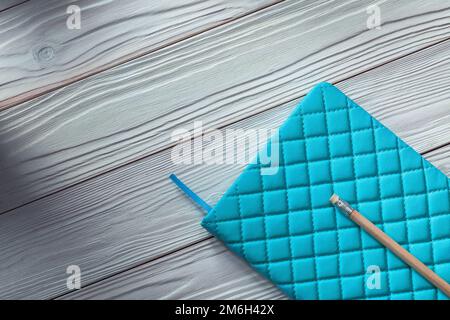 Blauer Notizblock mit klassischem Bleistift auf weißen Holzbrettern im Vintage-Stil Stockfoto