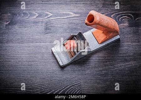 Handliches Mini-Holzbearbeitungsflugzeug im Vintage-Stil auf Holzbrettern. Stockfoto