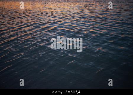 Details des schimmernden Wassers, während die Sonne über dem Meer, dem Golf von Mexiko untergeht Stockfoto