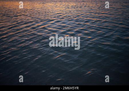 Details des schimmernden Wassers, während die Sonne über dem Meer, dem Golf von Mexiko untergeht Stockfoto