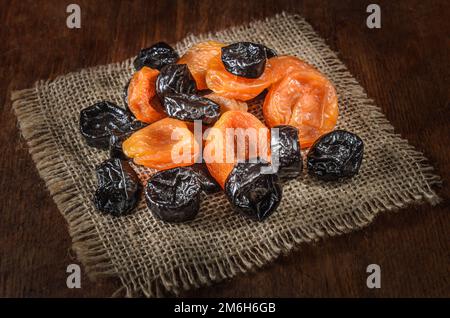 Getrocknete Aprikosen und andere getrocknete Früchte auf dunklem Holzhintergrund Stockfoto