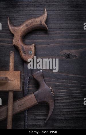 Rostige Handsäge, alte Markierungslehre, Klauenhammer, vertikale Abbildung. Stockfoto