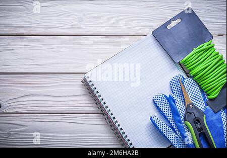 Weiche Schutzhandschuhe mit Twist Tie Tie Tie Tie That Schutzhandschuhe Copybook Gartenschere Konzept. Stockfoto