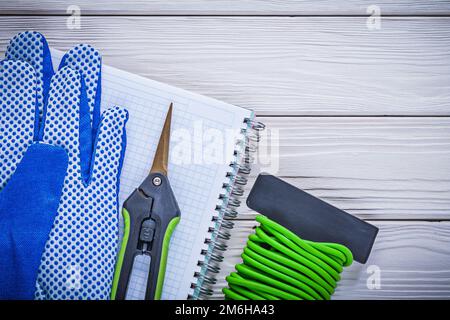 Weiche Sicherheitshandschuhe mit Twist Tie Tie Tie Tie Tie To Handschuh Copybook Gartenschere Konzept. Stockfoto