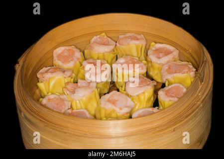 Dim Sum mit Fischfarce und Garnelen, Essensfotografie mit schwarzem Hintergrund Stockfoto