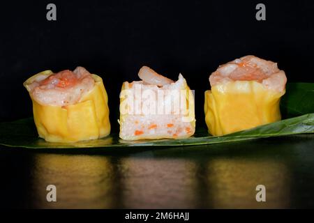 Dim Sum mit Fischfarce und Garnelen, Essensfotografie mit schwarzem Hintergrund Stockfoto