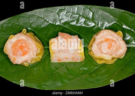 Dim Sum mit Fischfarce und Garnelen, Essensfotografie mit schwarzem Hintergrund Stockfoto