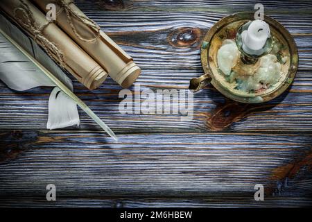 Klassische Papierrollen Kerzenhalter Kerze auf blauem Holzbrett. Stockfoto