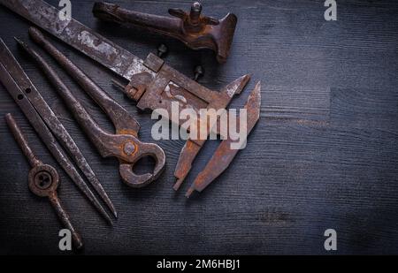Alte rostige Werkzeuge auf altem Brett. Stockfoto
