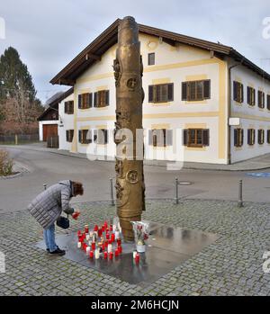 Eine Frau zündet eine Kerze zum Gedenken an Papst Benedikt XVI. Vor der Benedikt-Säule und dem Geburtsort von Papst Benedikt XVI. In Maktl a. Inn, Upper Stockfoto