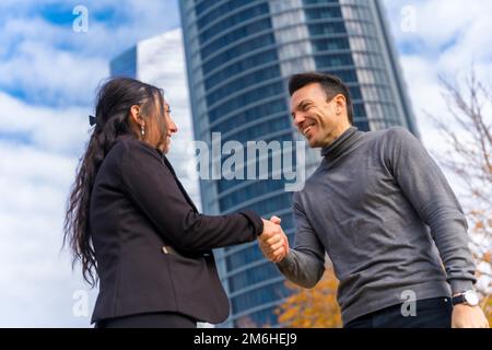 Multiethnischer Geschäftsmann und Geschäftsfrau, Begrüßung durch Händeschütteln und Lächeln Stockfoto