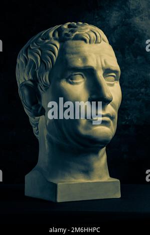 Bronzefarbenes Gipsexemplar der antiken Statue von Guy Julius Caesar Octavian Augustus für Künstler auf dunklem, strukturiertem Hintergrund. Stockfoto