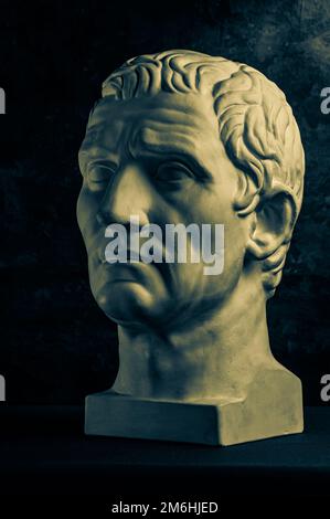 Bronzefarbenes Gipsexemplar der antiken Statue von Guy Julius Caesar Octavian Augustus für Künstler auf dunklem, strukturiertem Hintergrund. Stockfoto