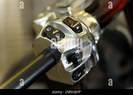 Der Handgriff des Gaspedals und die Steuerung der Beleuchtungseinrichtungen am Lenker eines Motorrads. Nahaufnahme. Transportkonzept. Stockfoto