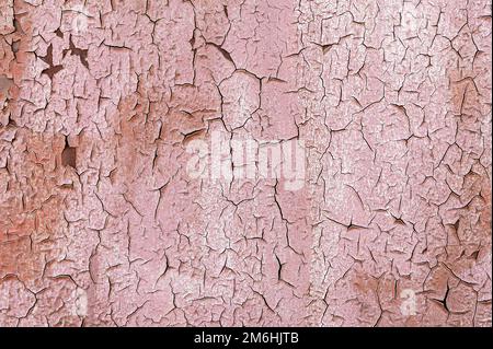 Pinkfarbene, abblätternde Farbe auf einer Metalloberfläche. Rote Grunge-Textur Stockfoto