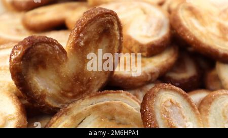 Frischer Blätterteig Palmkeks in Herzform. Klassisches französisches Gebäck. Schweinear, Elefantenohrkeks, französische Herzen. Stockfoto