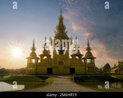 Goldener Tempel bei Sonnenuntergang. Buddhistischer Tempel im Inneren des Wat Rong Khun (Weißer Tempel). Es ist das wichtigste Reiseziel in Chiang Rai Stockfoto