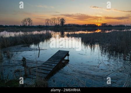 Fußgängerbrücke am Ufer des Sees und Blick auf den Sonnenuntergang Stockfoto