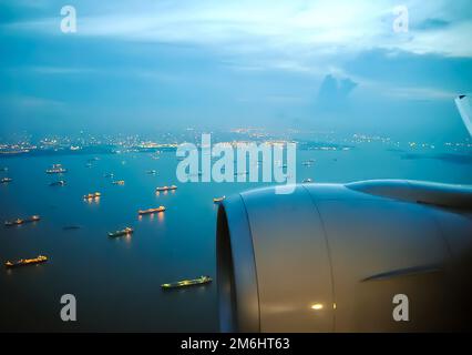 Flug des Flugzeugs über den Hafen, sichtbare Schiffe auf dem Wasser. Stockfoto