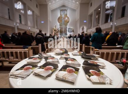 Stuttgart, Deutschland. 04. Januar 2023. Zahlreiche Bilder von Papst Emeritus Benedict XVI., der gestorben ist, liegen auf einem Tisch im Eingangsbereich der Kathedrale St. Eberhard. Besucher feierten ein päpstliches Requiem für Papst Benedikt XVI. In der Kathedrale. Kredit: Christoph Schmidt/dpa/Alamy Live News Stockfoto