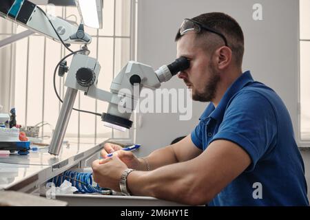 Der Zahntechniker beschäftigt sich mit der Modellierung von künstlichem Zahnersatz. Stockfoto