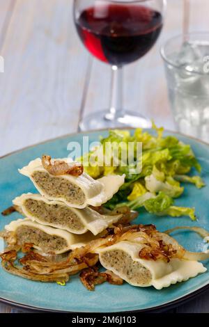 Hälften schwäbischer Maultaschen mit Salat Stockfoto