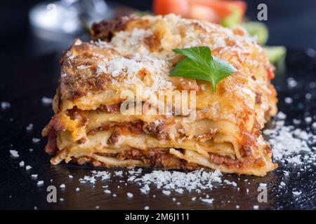 Frische Lasagne auf schwarzem Schiefer Stockfoto