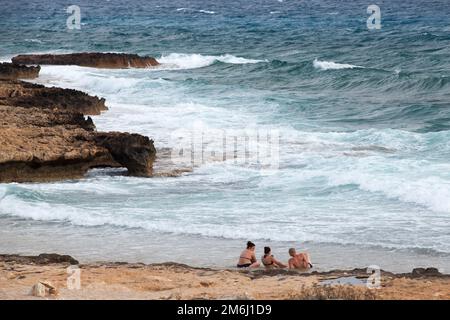 Ayia Napa, Zypern - 11. Juni 2018: Felsen an der Küste von Ayia Napa Resort Town, Zypern. Die Leute sitzen am Sandstrand Stockfoto