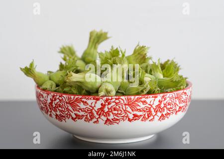 Grüne frische Haselnüsse in einer Schüssel. Stockfoto