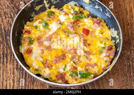 Rühreier in einer Pfanne auf Holz Stockfoto