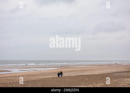 Zwei Personen, die am Strand in wnter in Noordwijk aan Zee, Niederlande, spazieren gehen Stockfoto