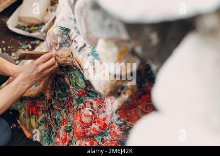 Man Mosaik Meister, der Salt Glas Mosaik Panel macht. Männlicher Mosaiker bei der Arbeit. Stockfoto