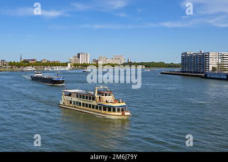 Rotterdam, Niederlande - August 2022: Touristenboot und Industriekahn auf dem Fluss Nieuwe Maas in Rotterdam. Stockfoto