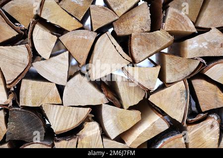 Gehacktes Brennholz im Holzhaufen. Holzstapel auf der Winterstraße Stockfoto