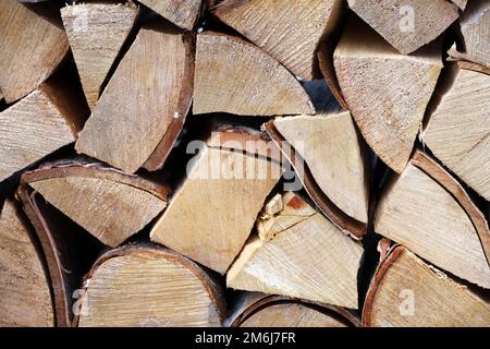 Gehacktes Brennholz im Holzhaufen. Holzstapel auf der Winterstraße Stockfoto