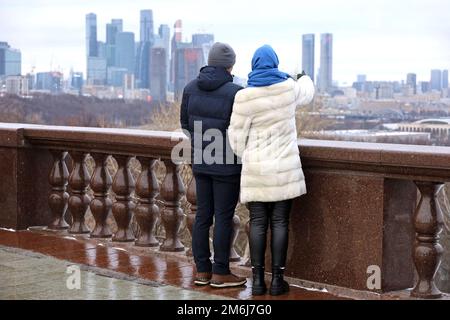 Ein paar Touristen, die das Panorama und die Wolkenkratzer von Moskau sehen. Winterreisen in Russland oder Immobilien kaufen Stockfoto