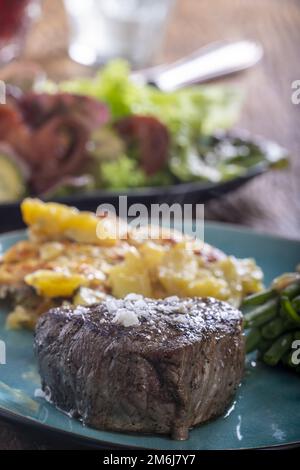 Steak mit Bohnen und Kartoffelgratin Stockfoto