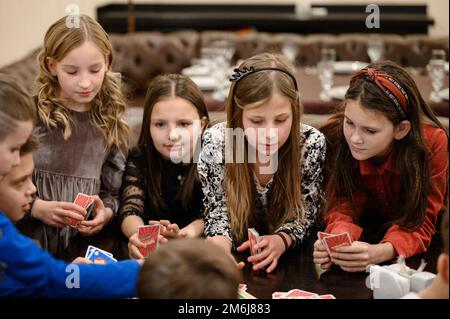 Ivano-Frankivsk, Ukraine 20. November 2022: Kinder spielen Brettspiele, spielen Karten mit Kindern an Geburtstagsferien, Lernspiele. Stockfoto