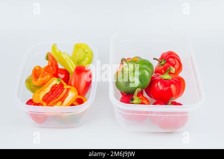Gemischte organische rote, grüne und gelbe Paprika in einem Behälter. Lagerung von Gemüse. Raumordnung in der Küche Stockfoto