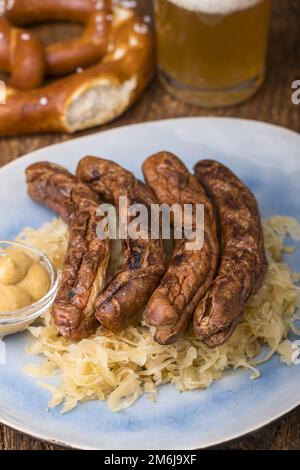 Nürnberger Würstchen mit Sauerkraut auf dem Teller Stockfoto