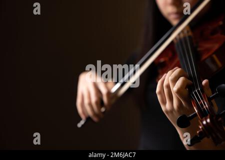 Teenager, die in formeller Kleidung Geige spielen Stockfoto