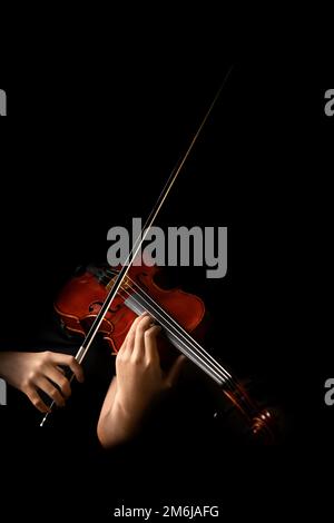 Teenager, die Geige im schwarzen Hintergrund spielen Stockfoto