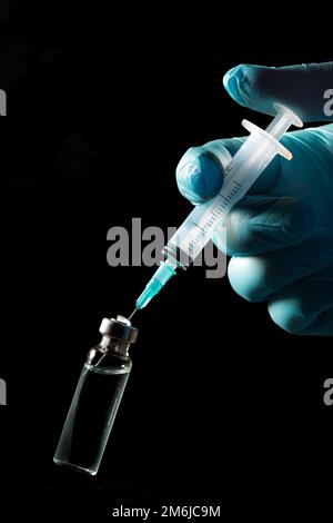 Nahaufnahme des Gürtelrose-Impfstoffbehältnisses und der Spritze in der Hand Stockfoto