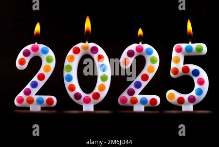 Farbige Kerzen schreiben Zahlen Flamme Frohes neues Jahr 2025 Stockfoto