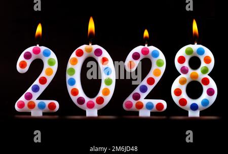 Farbige Kerzen schreiben Zahlen Flamme Frohes neues Jahr 2028 Stockfoto