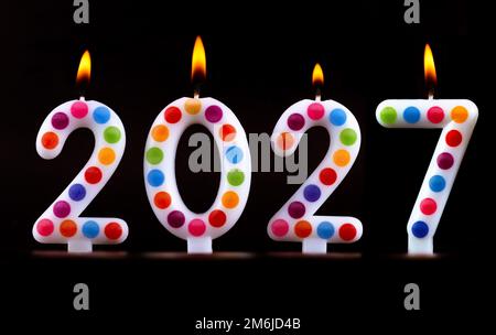 Farbige Kerzen schreiben Zahlen Flamme Frohes neues Jahr 2027 Stockfoto